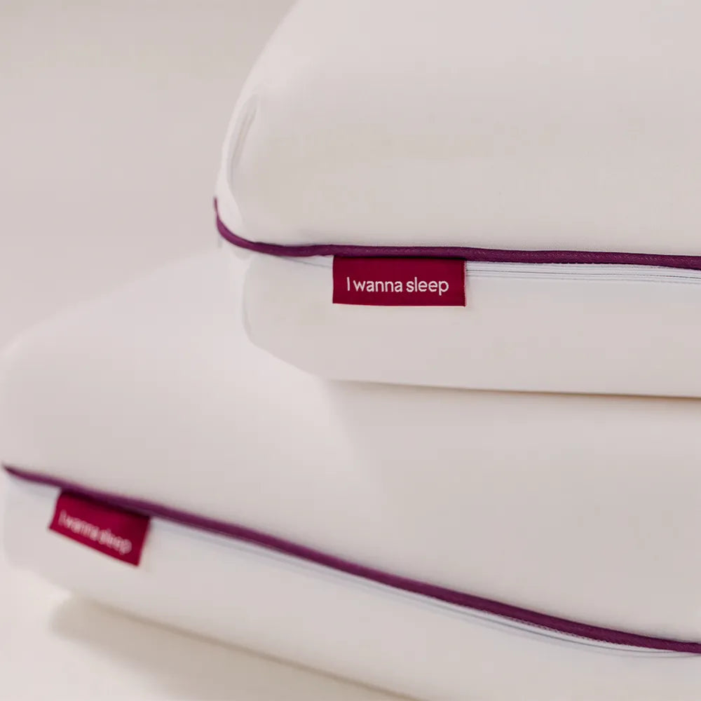 travesseiros IWS Memory Foam Original® nos detalhes demonstrando sua capa de tecido Smoothy que permite a circulação do ar, evitando a proliferação de ácaros, proporcionando uma sensação de frescor, com um toque super macio e com capa lavável para
facilitar a limpeza. Em destaque nos travesseiros nasa temos a etiqueta i wanna sleep na cor roxa com escrita em branco.