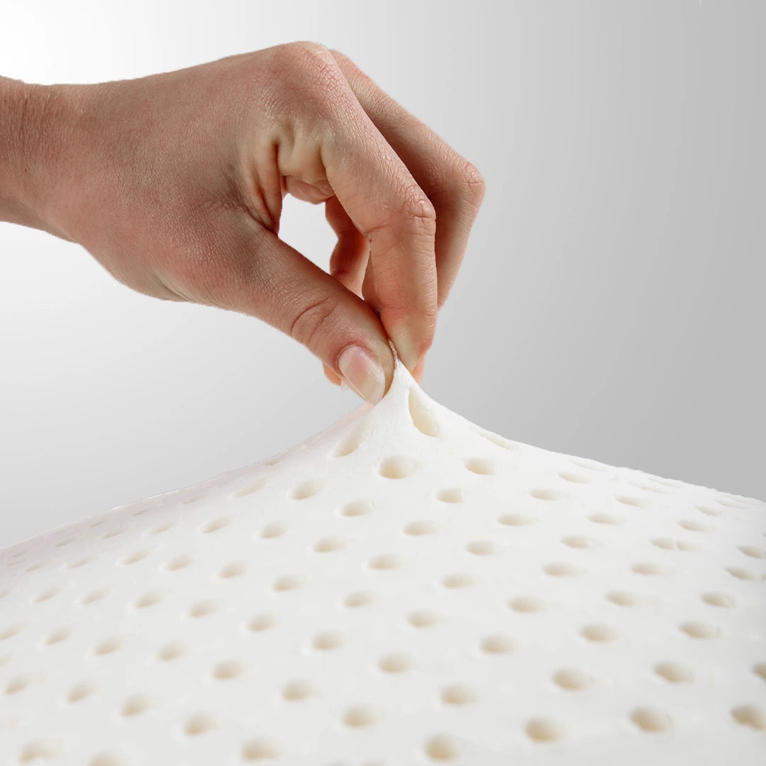 mão puxando o látex natural do travesseiro iws mostrando que o  látex tailandês é naturalmente resistente à poeira e aos ácaros, tornando nosso travesseiro uma escolha saudável para quem sofre de alergias.
