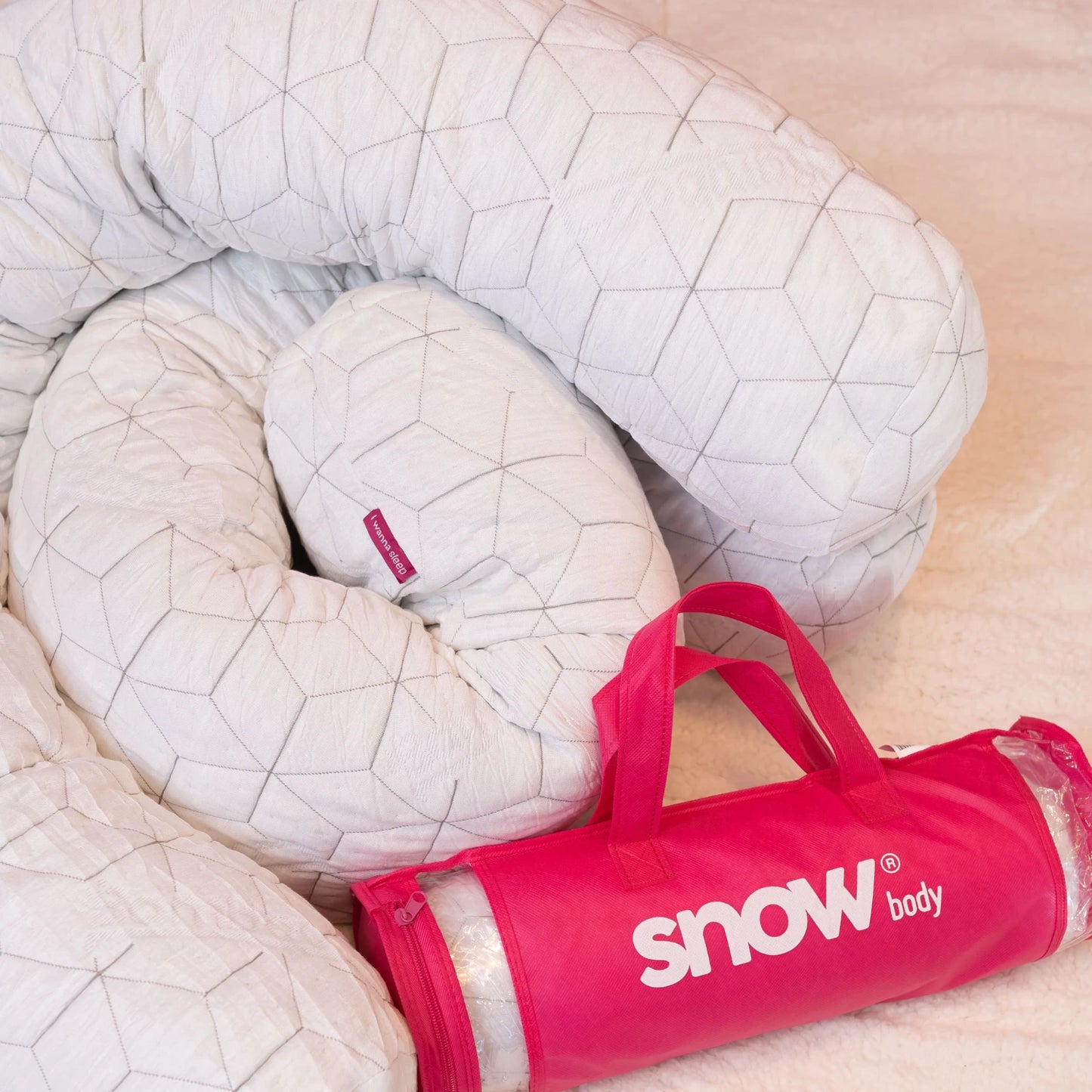 Dois travesseiros de corpo snow body da i wanna sleep sua bag e embalagem rosa com a logo do snow body na frente