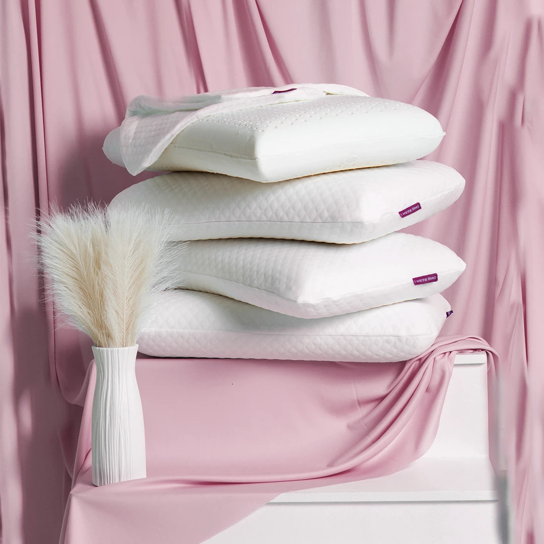 travesseiros IWS Original Látex® empilhados um sobre o outro com um fundo rosa
