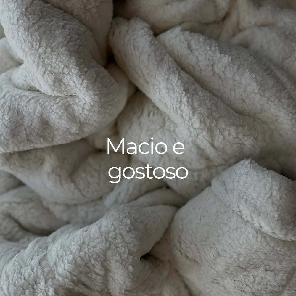Imagem demonstrando de perto a textura macia e aconchegando do cobertor quentinho Huggy da I wanna sleep com dupla face, sendo uma delas sheepskin sintético possui ação hipoalergênica, se tornando uma opção ideal para pessoas alérgicas, ao contrário das peles de ovelhas reais, que podem causar reações alérgicas devido a proteínas presentes na lã. O texto "Macio e gostoso" sobrepõe a imagem