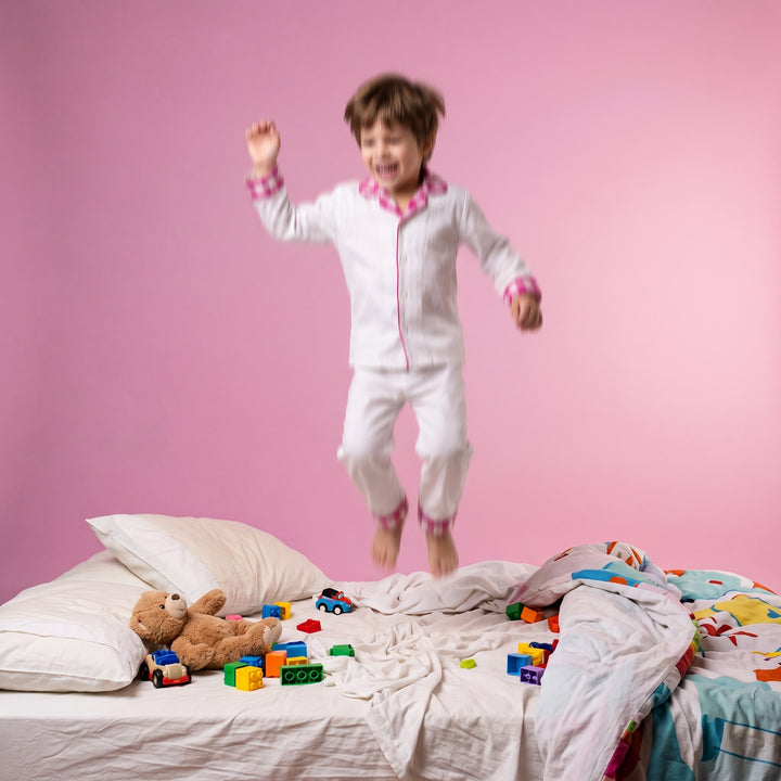 Foto lifestyle: criança resistindo para dormir, quarto com luz acesa, expressão de agitação.