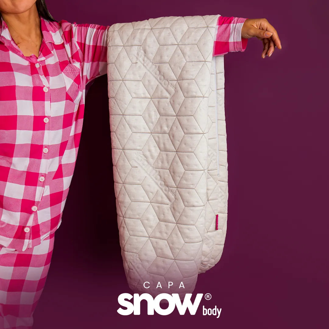 Mulher de pijama xadrez branco e rosa da i wanna sleep segurando nossa capa para travesseiro de corpo do snow body com logo do produto na parte inferior da imagem