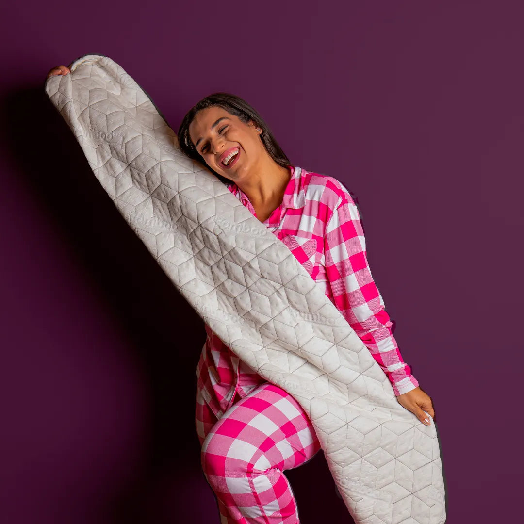 Mulher sorridente abraçando a capa para travesseiro de corpo Snow Body da I Wanna Sleep, destacando o conforto e maciez do tecido de bambu.