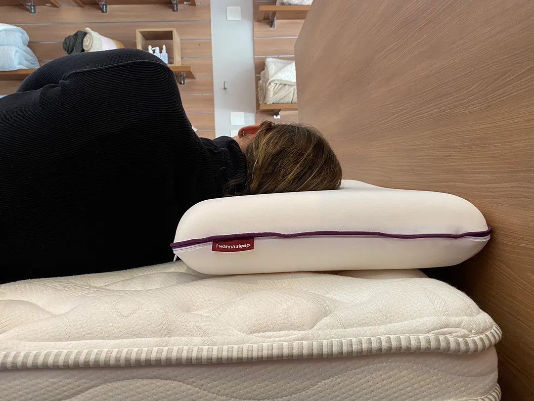 Mulher deitada de lado demonstrando a altura  de 11cm do seu travesseiro confortável memory foam da IWS que alivia tensões proporcionando noites de sono mais tranquilas