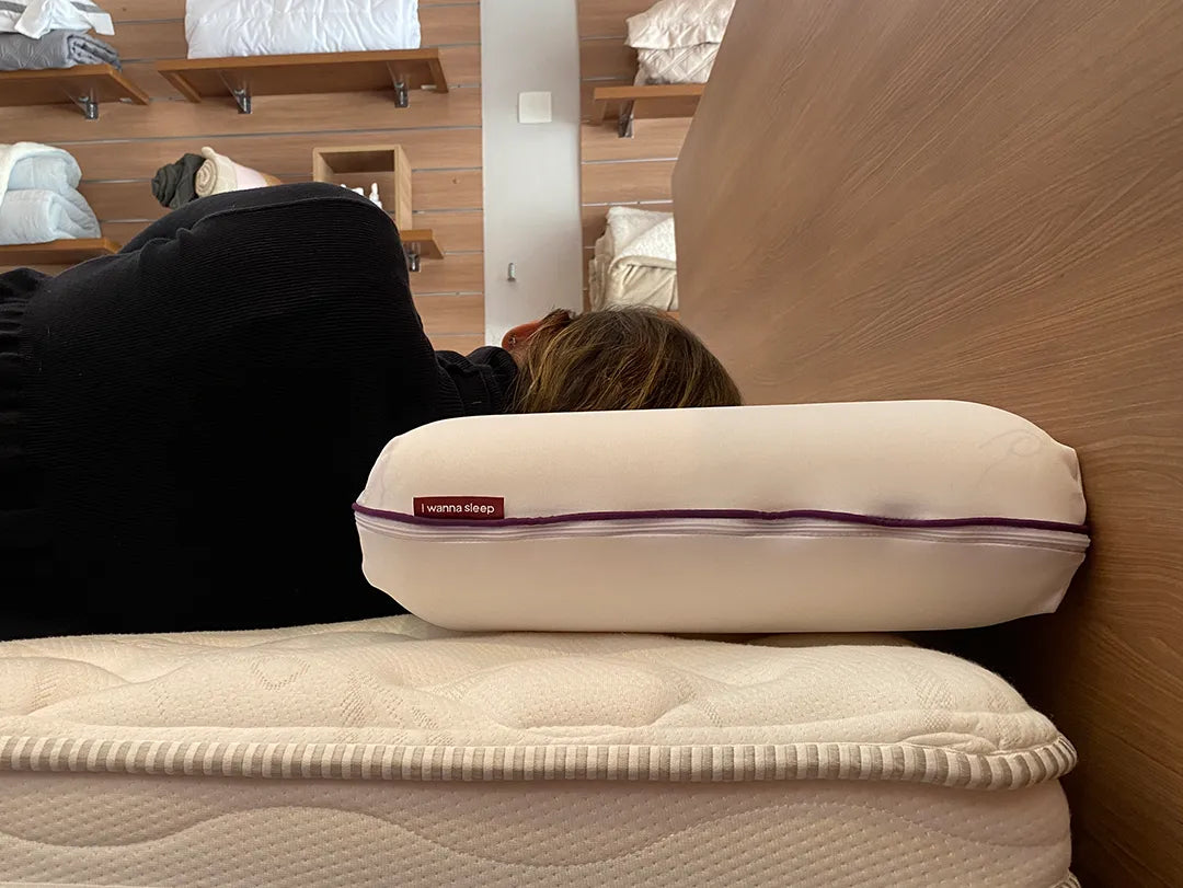 Mulher deitada de lado demonstrando a altura  de 14cm do seu travesseiro confortável memory foam da IWS que alivia tensões proporcionando noites de sono mais tranquilas