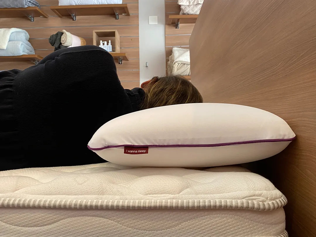 Mulher deitada de lado demonstrando a altura  de 16cm do seu travesseiro confortável memory foam da IWS que alivia tensões proporcionando noites de sono mais tranquilas